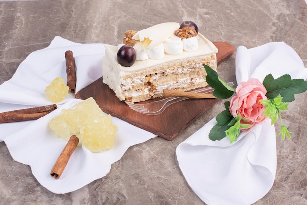 Pastel de chocolate blanco sobre tabla de madera con tela y dulces.