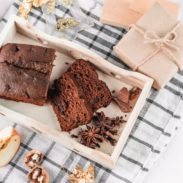 Pastel de chocolate con canela en bandeja de madera.