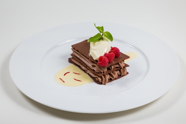 Pastel de chocolate con crema de chocolate bellamente colocado sobre un lugar blanco