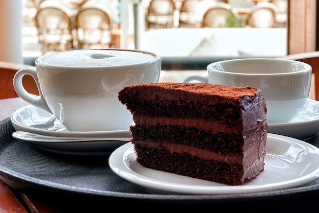 Pastel de chocolate y dos tazas de café.