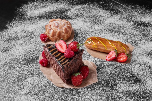 Pastel de chocolate con frutos rojos sobre negro.