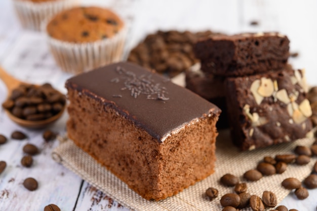 Pastel de chocolate en el saco con granos de café sobre una mesa de madera.