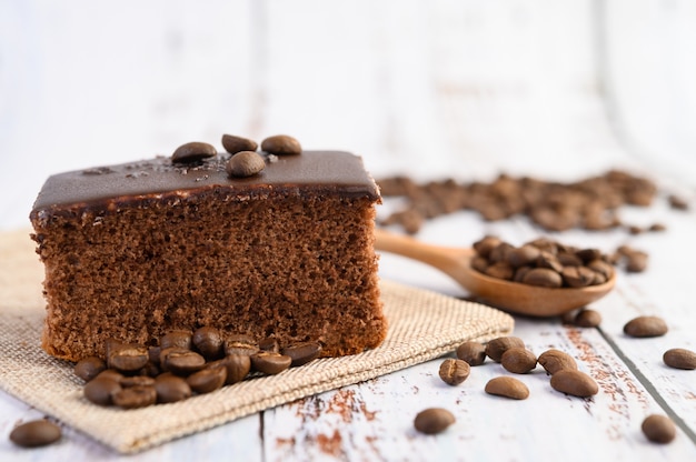 Pastel de chocolate en el saco con granos de café sobre una mesa de madera.