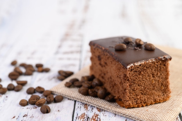 Pastel de chocolate en el saco con granos de café sobre una mesa de madera.