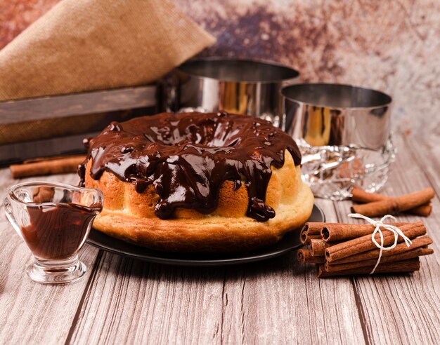 Pastel con cobertura de chocolate y palitos de canela