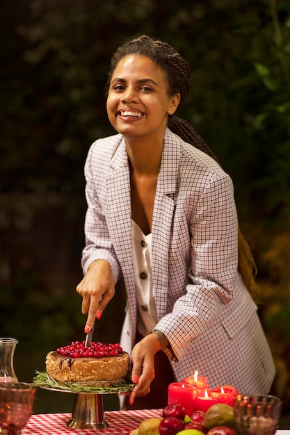 Pastel de corte de mujer sonriente de tiro medio