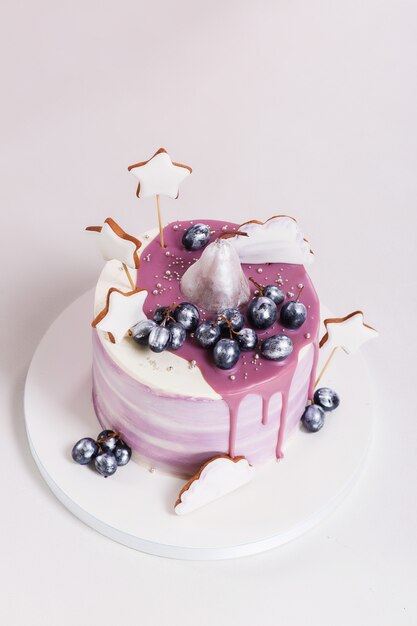 Pastel de cumpleaños decorado con arándanos y galletas.