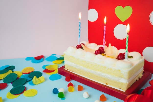 Foto gratuita pastel de cumpleaños con velas y caramelos iluminados