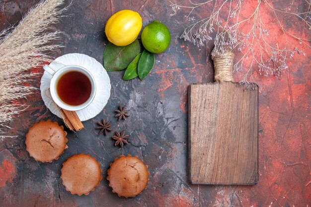 pastel de cupcakes una taza de té con canela espigas de trigo tabla de cortar anís estrellado