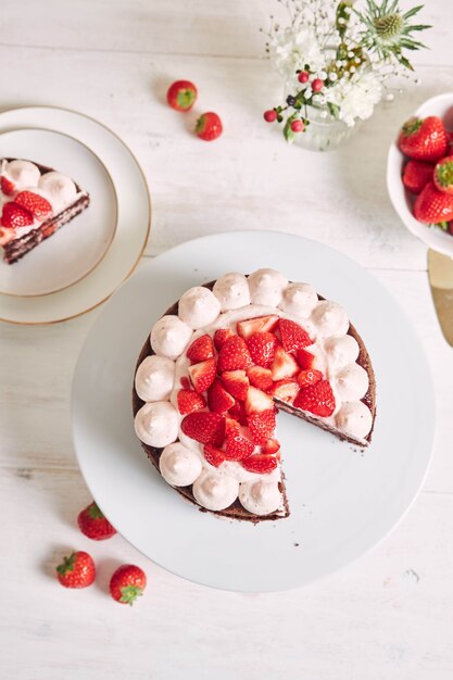 Pastel delicioso y dulce con fresas y baiser en un plato