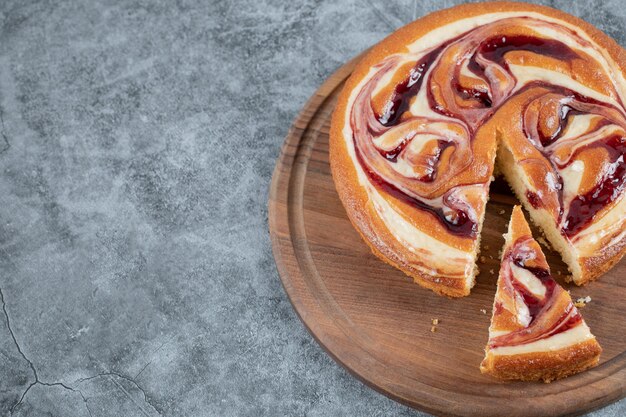 Pastel delicioso suave con ingredientes mixtos sobre tabla de madera.