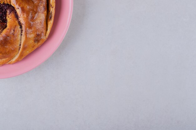 Pastel dulce en un plato sobre la mesa de mármol.