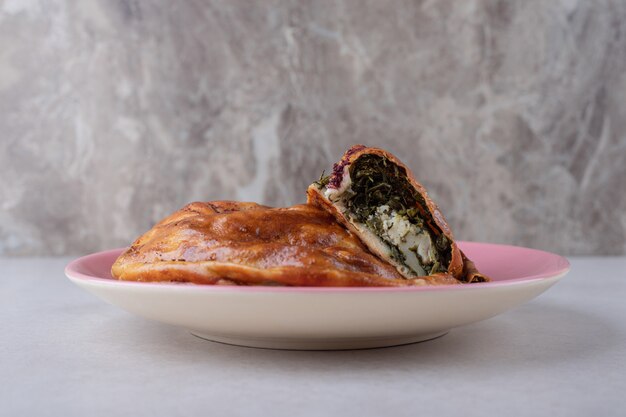 Pastel dulce en un plato sobre la mesa de mármol.