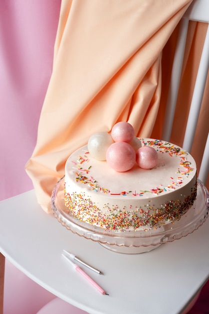 Pastel para evento de cumpleaños en silla con globos.
