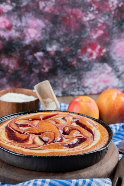 Pastel de fresa con melocotones amarillos alrededor.