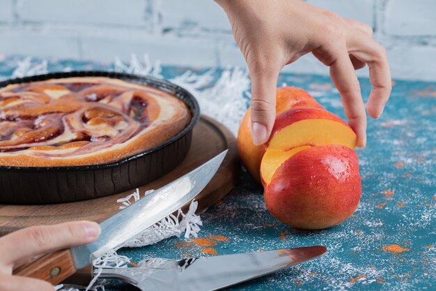 Pastel de fresa servido con melocotones rojos y amarillos.