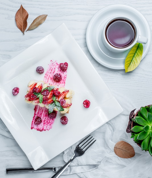 pastel con fresas y té en la mesa