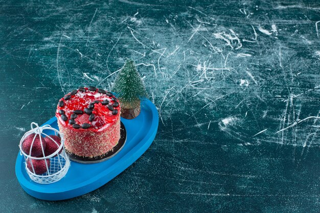 Pastel de frutas sabroso con bolas de Navidad y árbol de Navidad. Foto de alta calidad