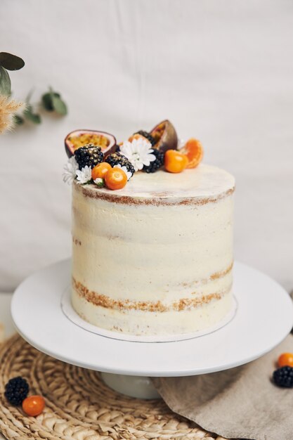 Pastel con frutos rojos y maracuyá junto a una planta