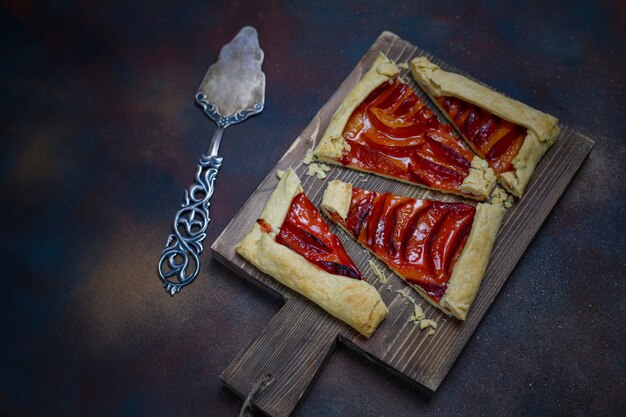 Pastel de galette de ciruelas frescas con ciruelas crudas en la oscuridad