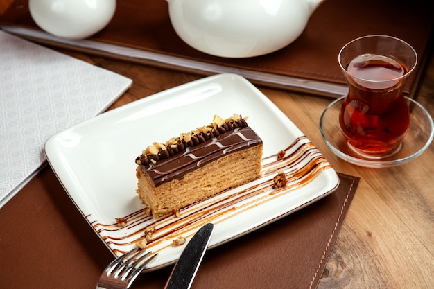 pastel de miel en capas con nueces de chocolate y mesa de teon negro