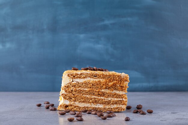 Pastel de miel dulce con granos de café sobre fondo de mármol.