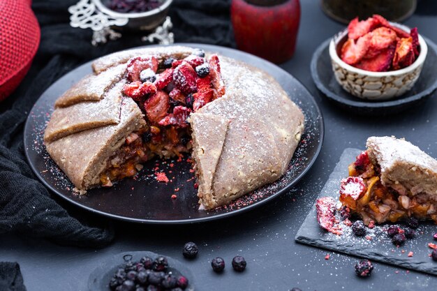 Pastel de nectarina fresca vegana cruda sobre una mesa oscura