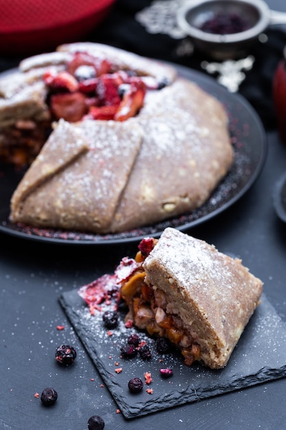 Pastel de nectarina fresca vegana cruda sobre una mesa oscura