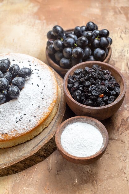 un pastel un pastel en el tablero cuencos de uvas azúcar pasas