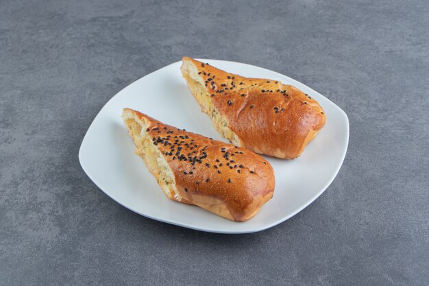 Pastel de queso medio cortado en un plato blanco.