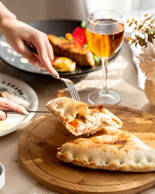 Pastel relleno a medio cortar con salsa de tomate salami y champiñones