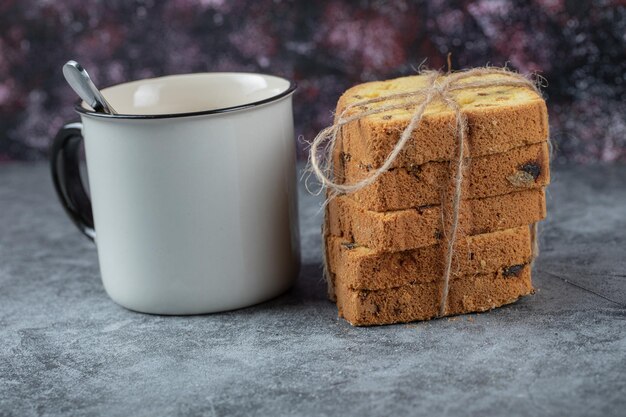 Pastel de rodajas servido con una taza de bebida.