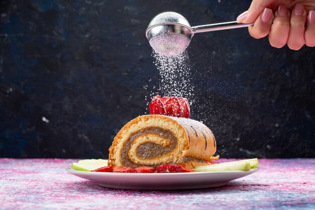 Pastel de rollo de vista frontal con frutas dentro de la placa blanca.