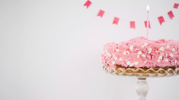 Pastel rosa decorado con velas