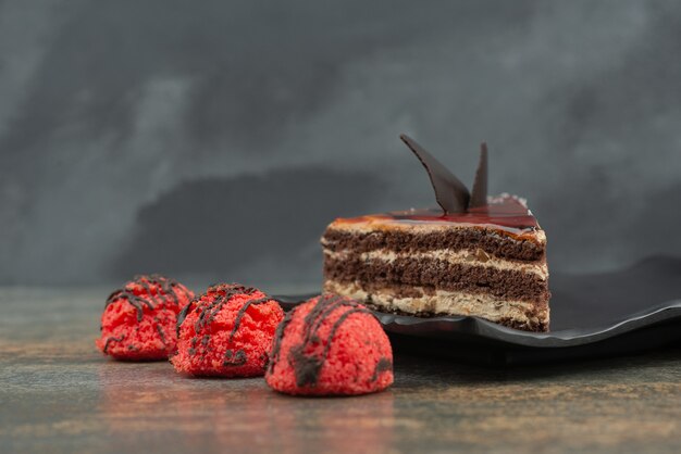 Pastel sabroso con caramelos rojos sobre superficie de mármol.