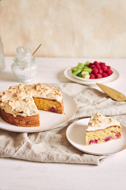 Pastel sabroso y delicioso con baiser y frambuesas en un plato