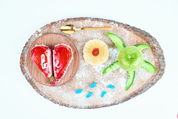 Pastel de San Valentín con forma de corazón rojo con frutas.