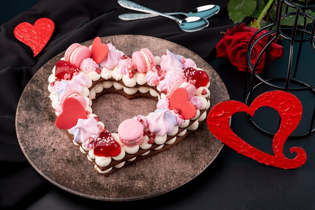 Pastel de san valentín en forma de corazón con rosa y plato