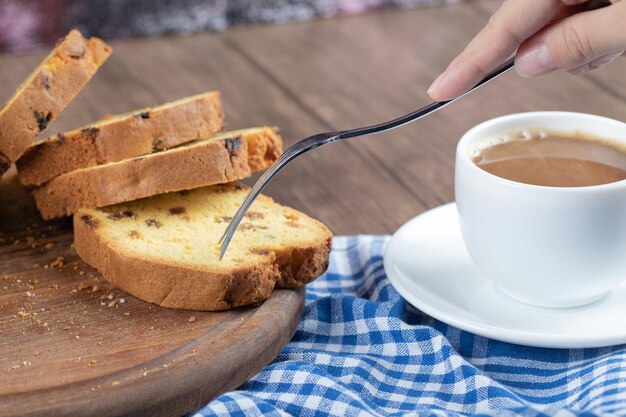 Pastel de sultana en rodajas servido con una taza de café.