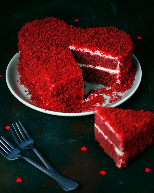 Pastel de terciopelo rojo en forma de corazón en la oscuridad