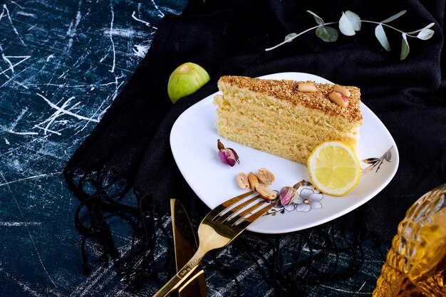 Pastel de vainilla aislado sobre fondo azul en un plato blanco.