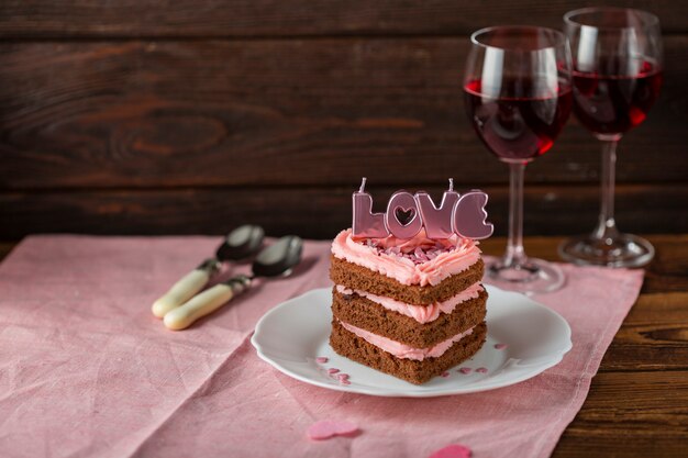 Pastel con velas y copas de vino.