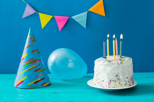 Pastel con velas y sombrero de fiesta
