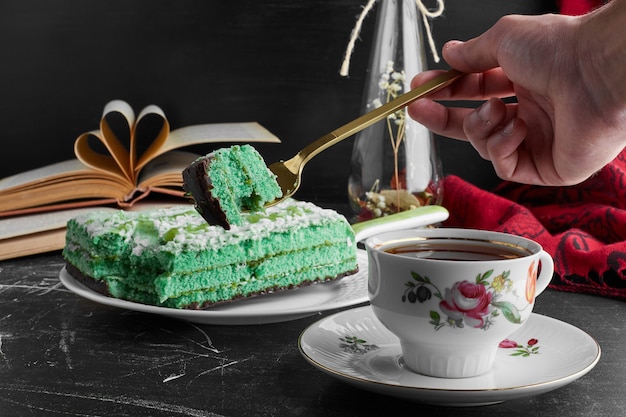 Pastel verde con pistacho y menta con una taza de té.