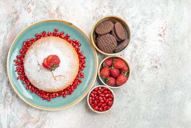 Pastel de vista superior con pastel de fresas con granada y fresas con galletas de chocolate