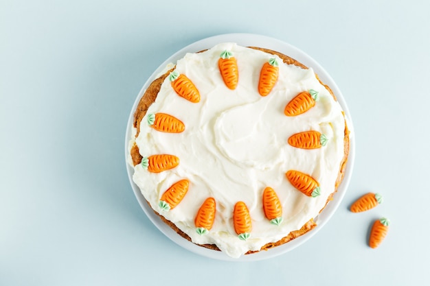 Pastel de zanahoria de Pascua con glaseado en mesa azul