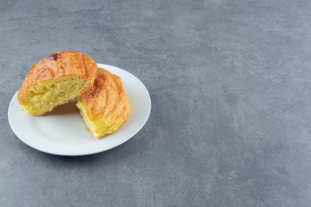 Pastelería casera de medio corte en un plato blanco.