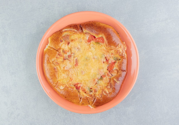 Pastelería casera con queso en plato naranja.