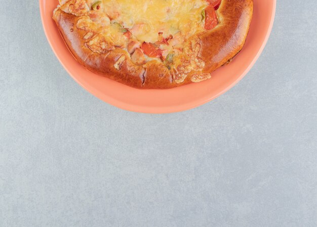 Pastelería casera con queso en plato naranja.