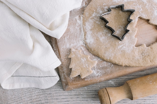 Pastelería cerca de cortador de galletas en tabla de cortar